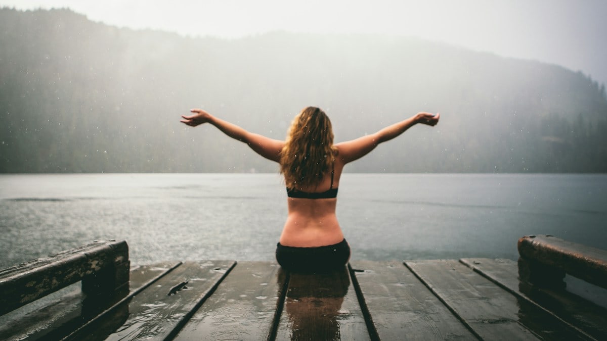 woman sitting on wooden dock